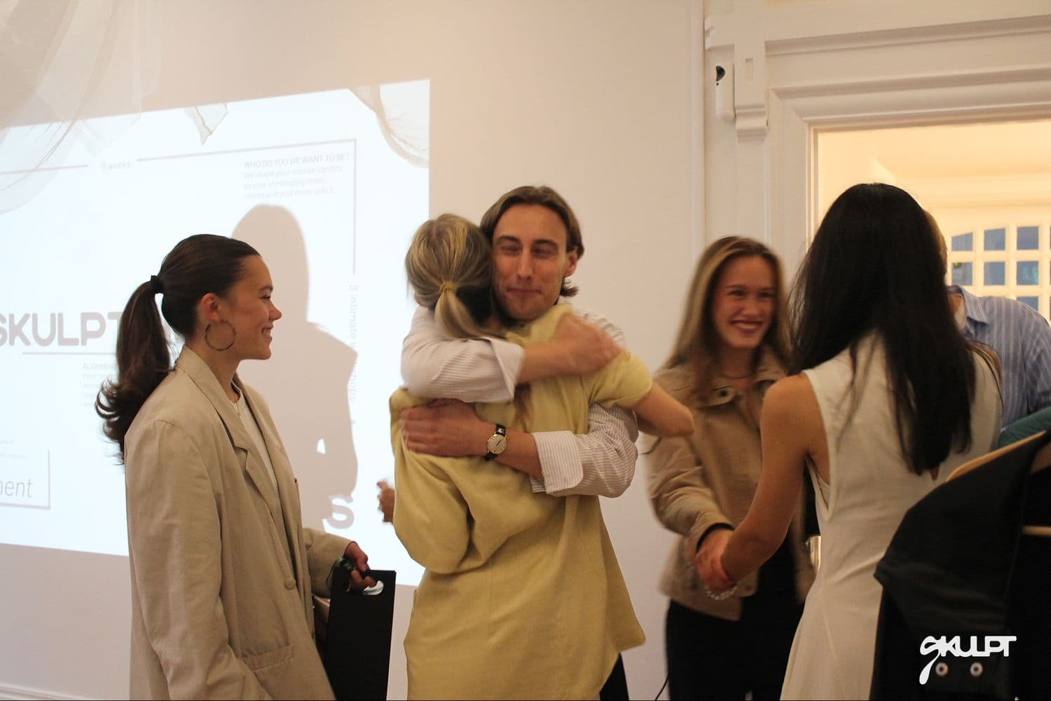 Founders embracing at a SKULPT event
