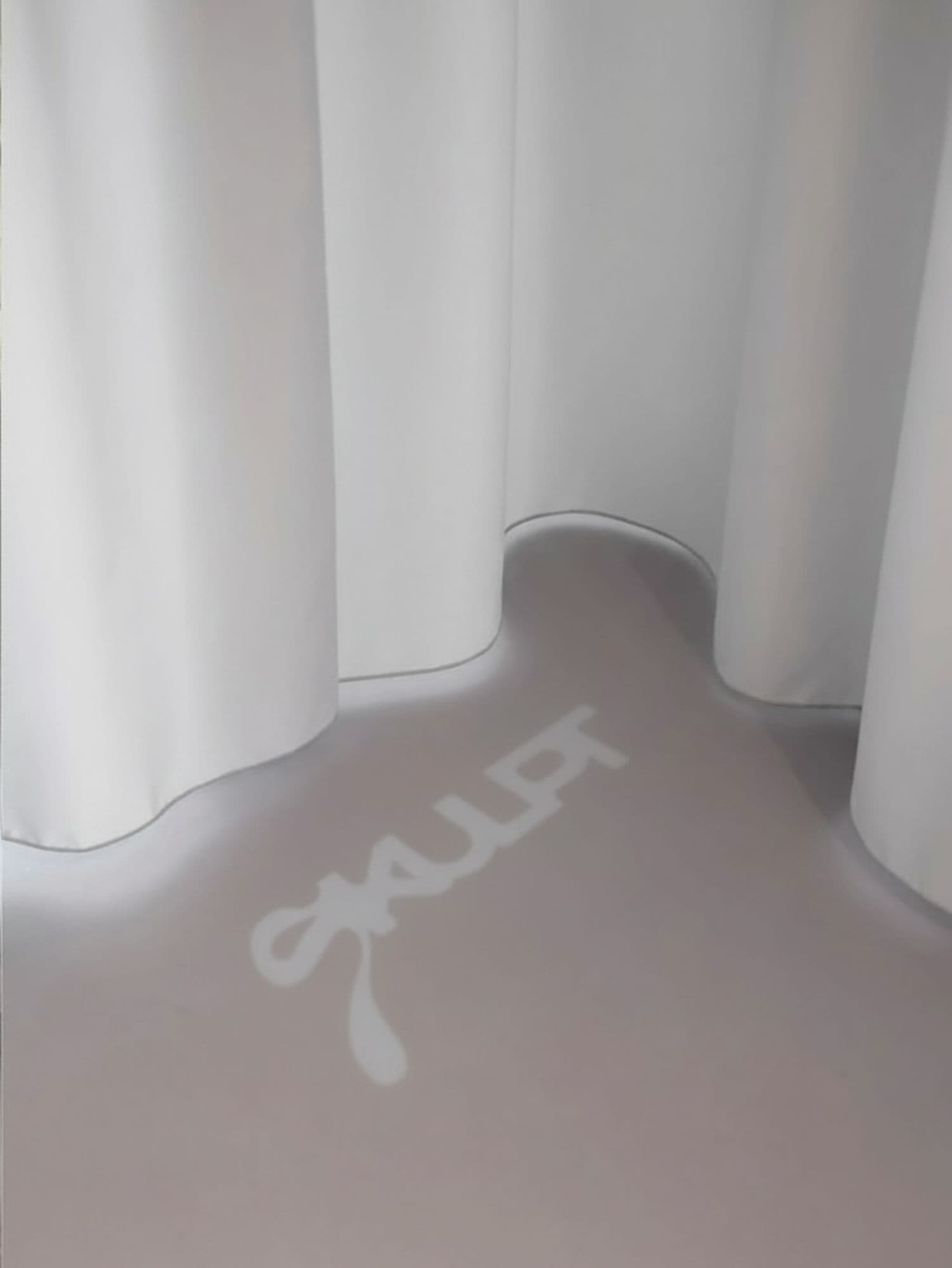 SKULPT logo projected across a draped floor