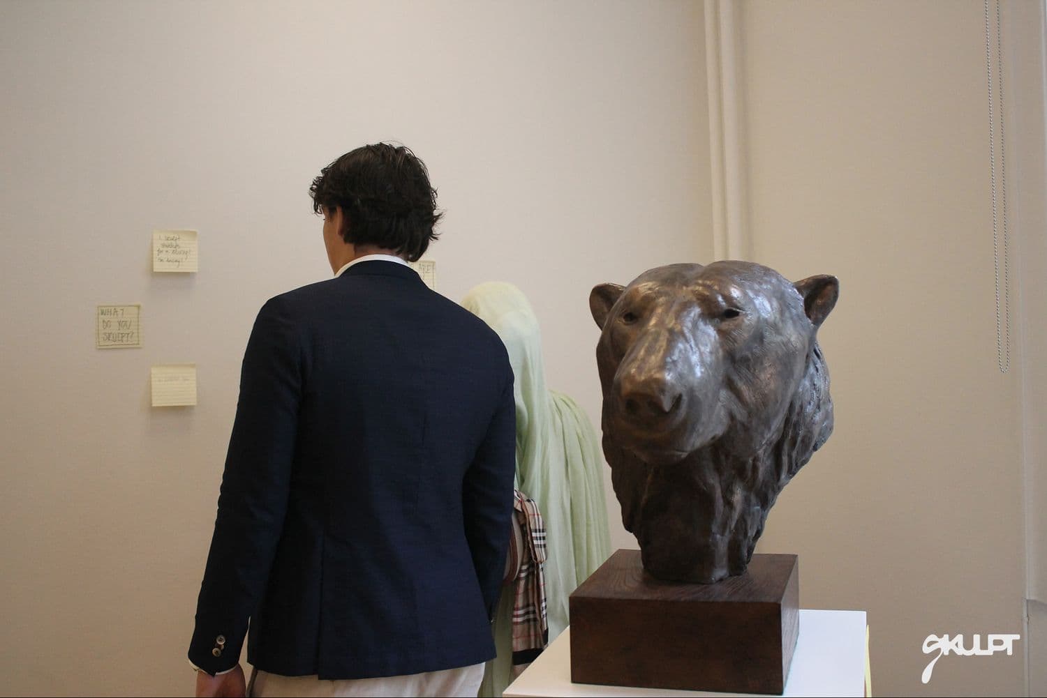 Guest studying a bronze sculpture in the space
