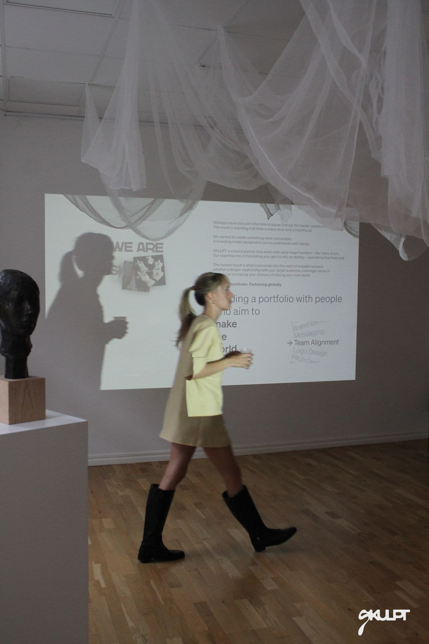 Guest walking past the WE ARE SKULPT projection